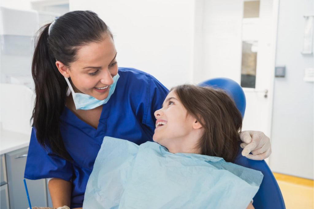 happy apointment between a pediatric dentist and the little girl